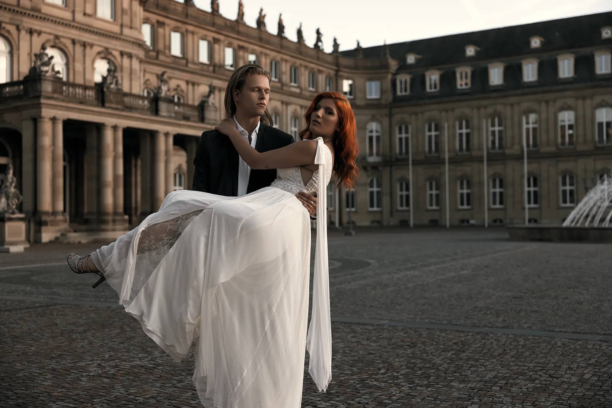 Ein Brautpaar vor einem majestätischen Schloss. Romantik und Eleganz vereint in einer atemberaubenden Kulisse.