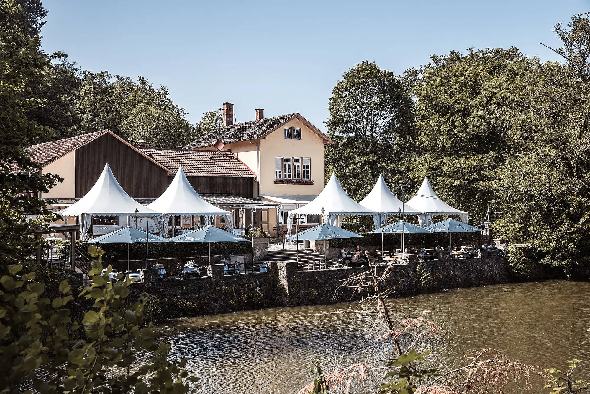 Die Hochzeitslocation am Waldsee in Freiburg, zeigt die Gaststätte Waldsee an einem wunderschönen Sommertag.